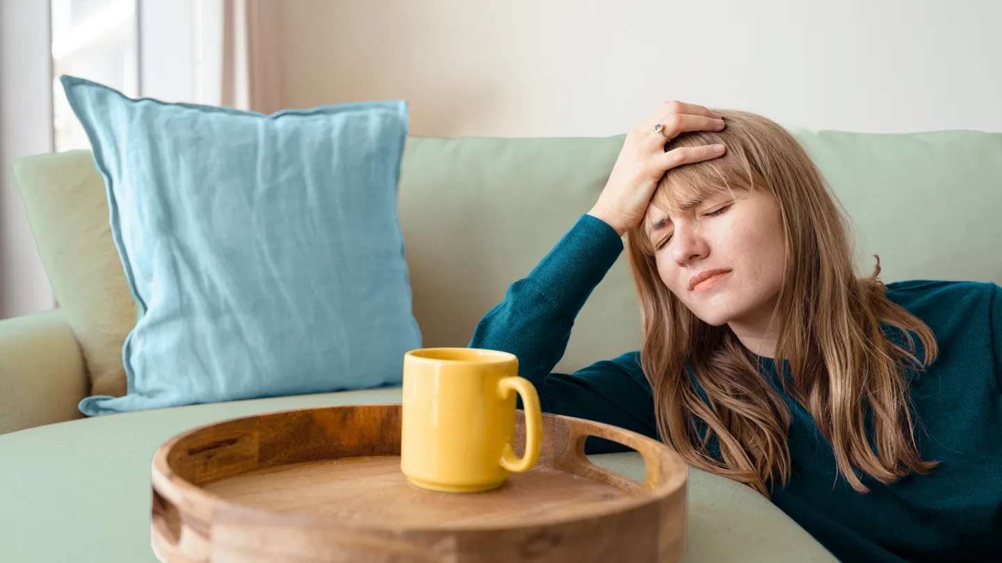 woman drinking coffee with a headache