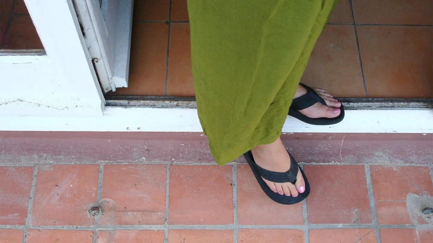 a woman with allergies taking her shoes off outside