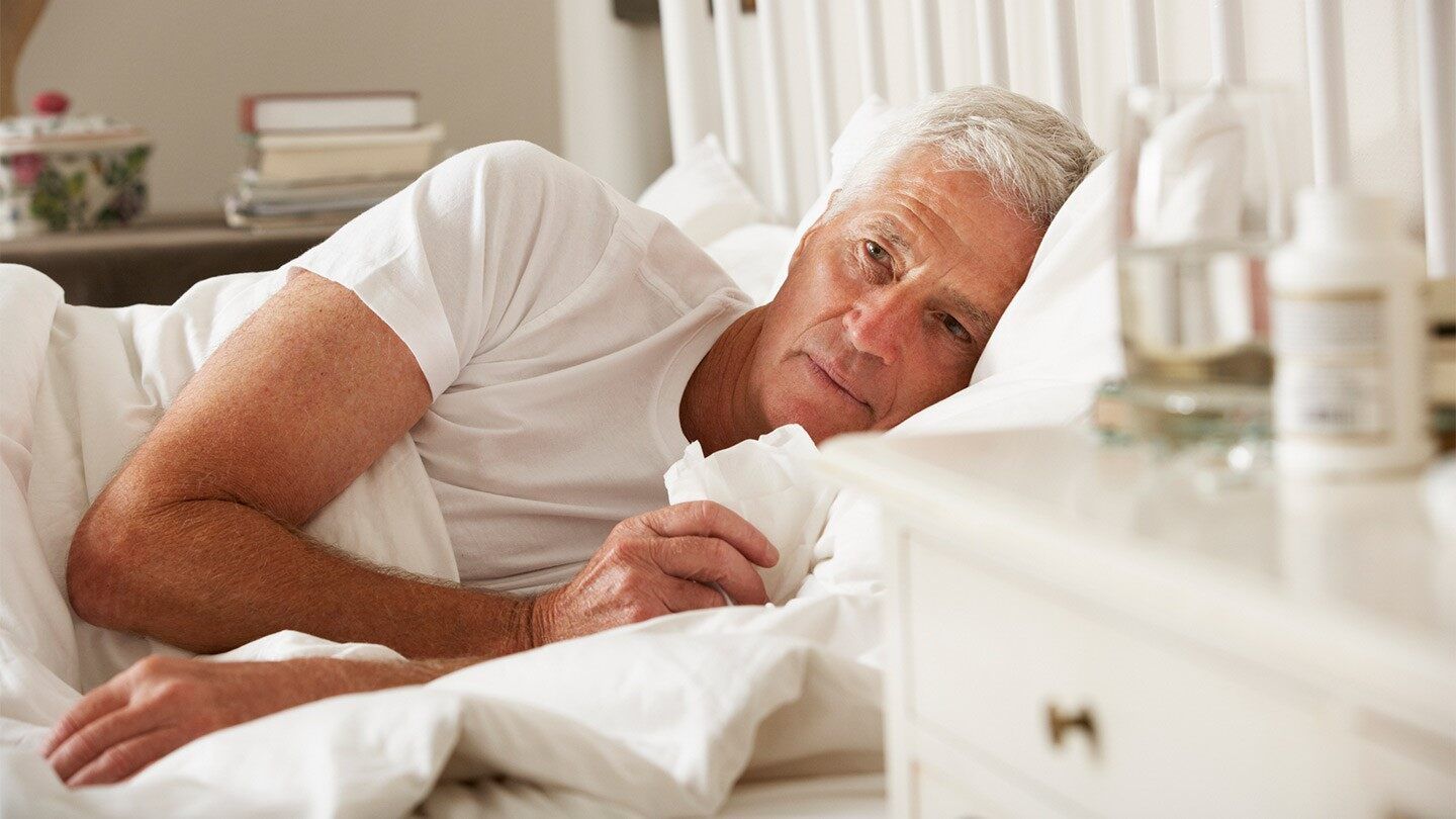 a man with allergies laying in bed