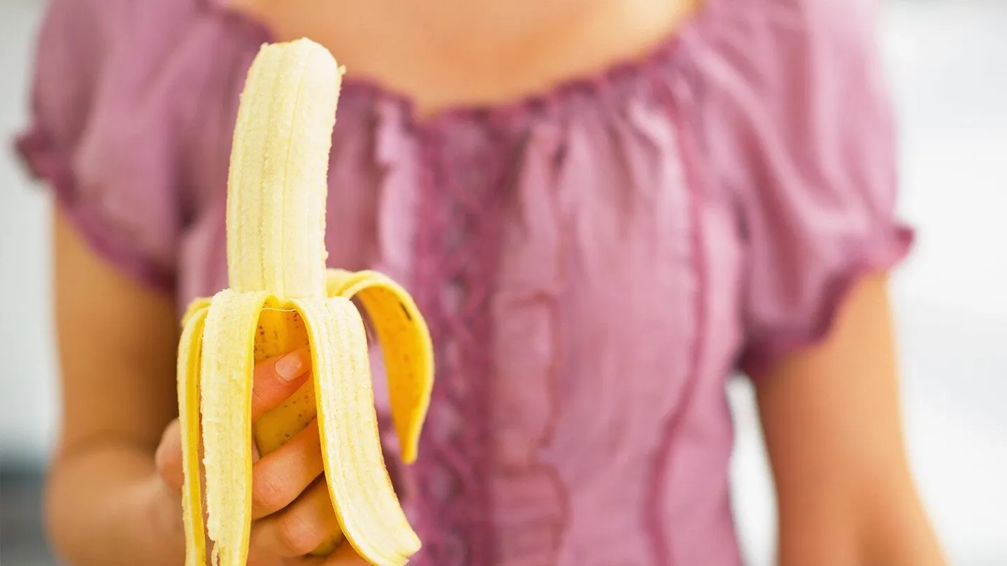 a woman with allergies eating a banana