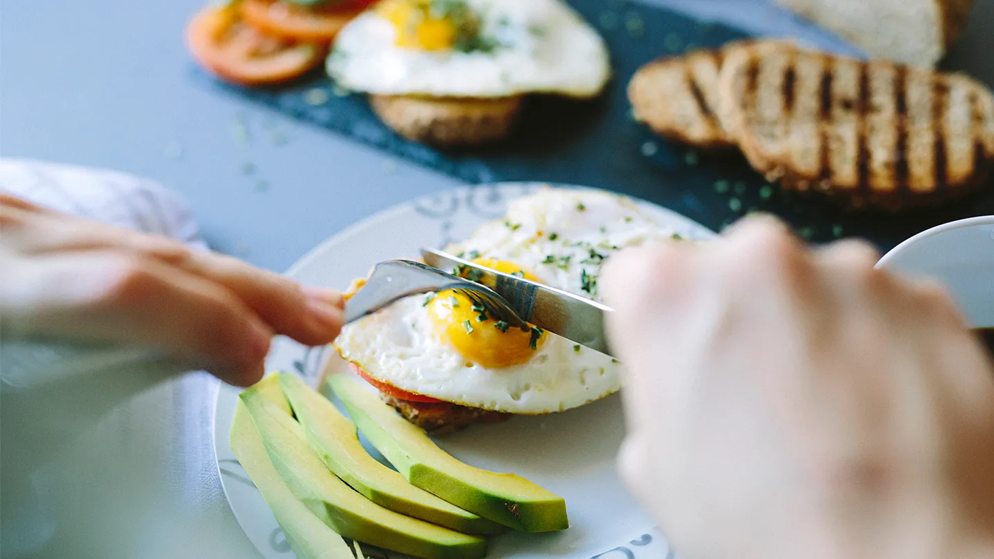 eating eggs on toast with avocado