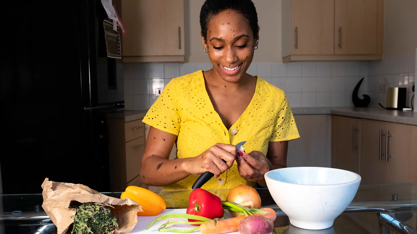 woman in yellow chopping vegetables