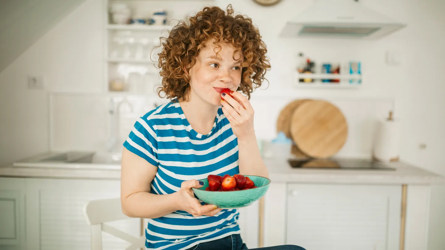 young woman eating strawberries
