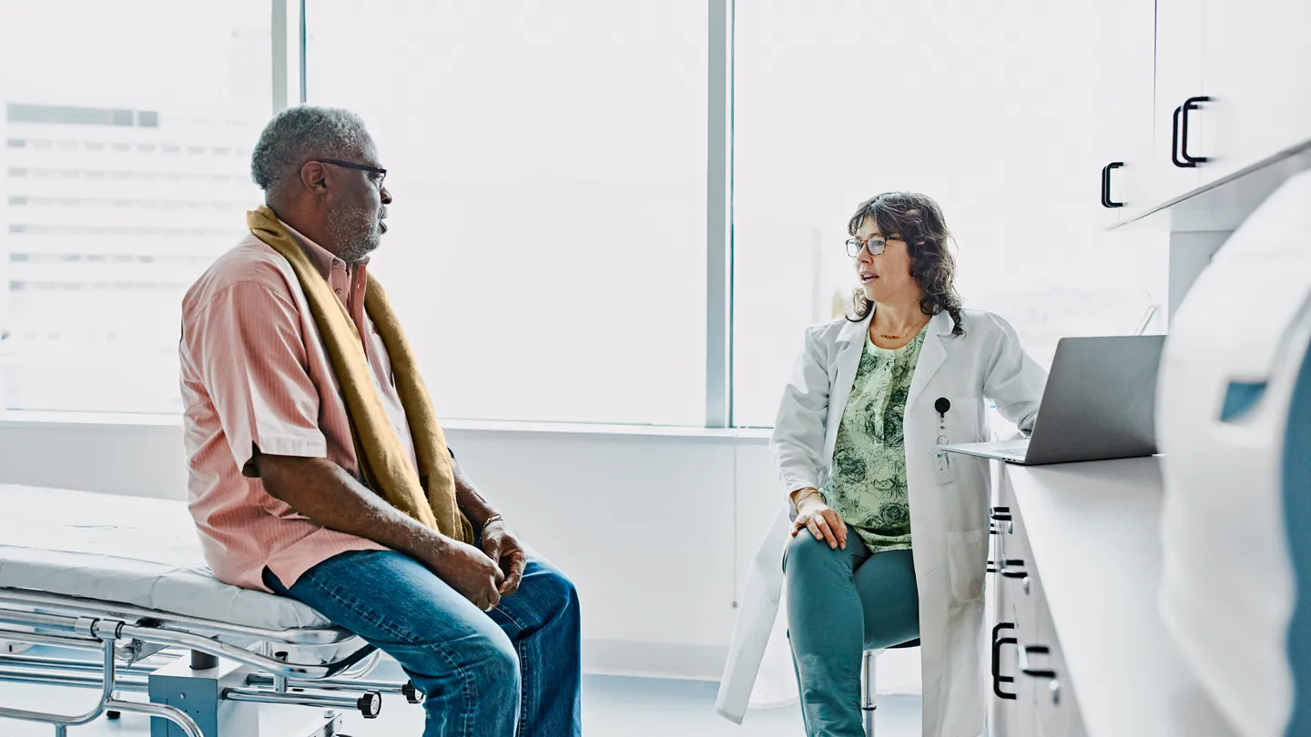 Black man talking with doctor in office