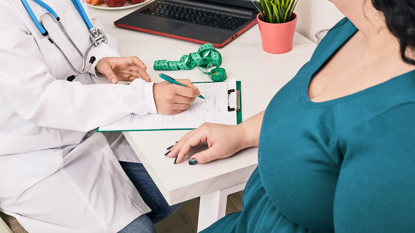 doctor talking to plus size woman about BMI waist measurement