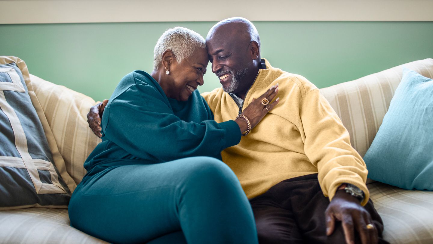 mature Black couple romantic on the couch
