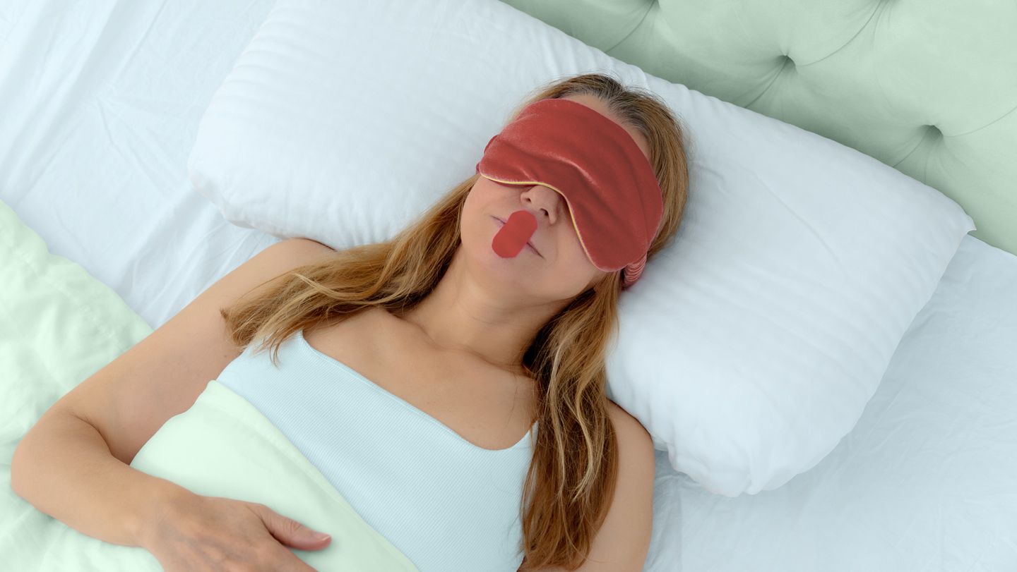 young woman lying in bed with a sleep mask and mouth tape over her mouth