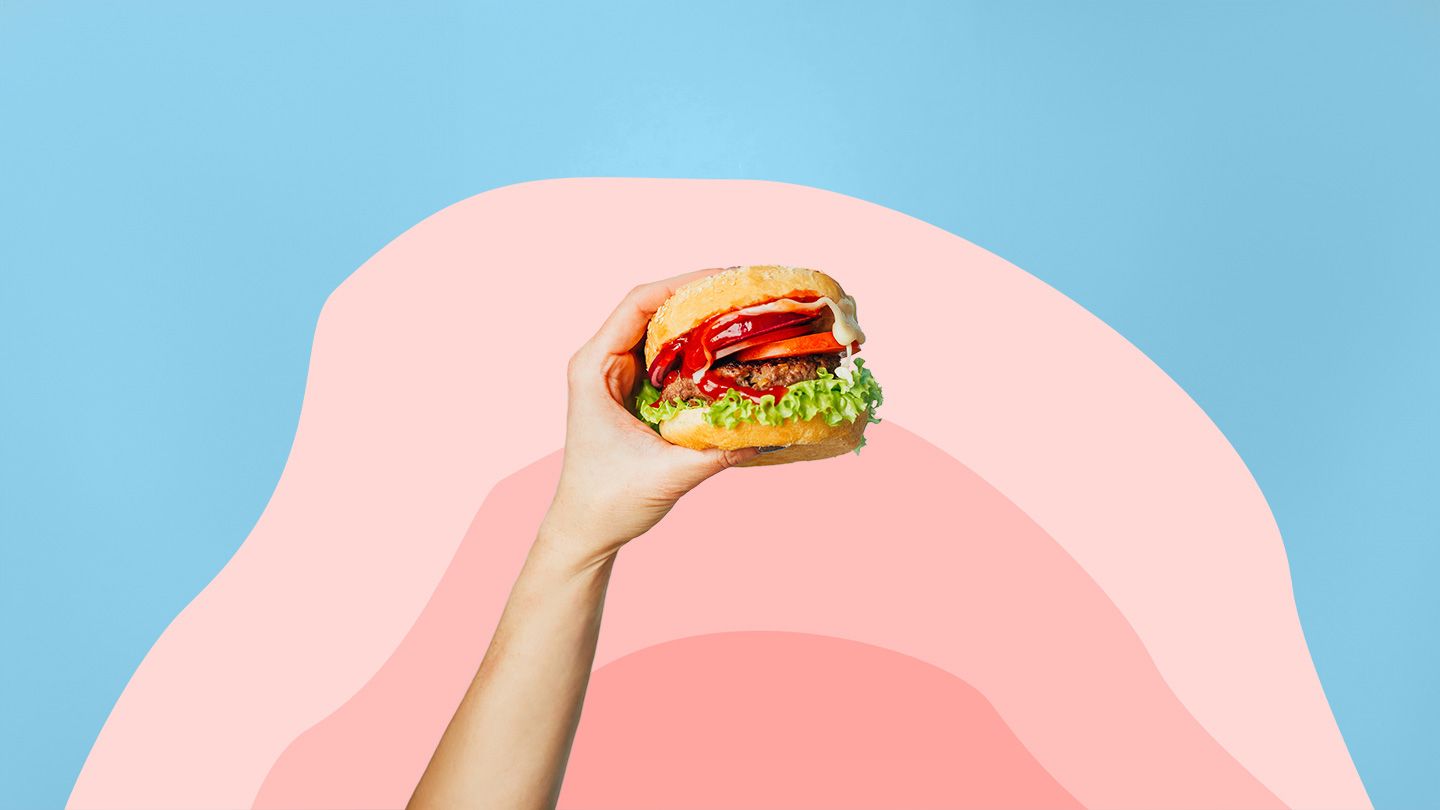 hand holding a burger in front of a wave shape gradient of corals