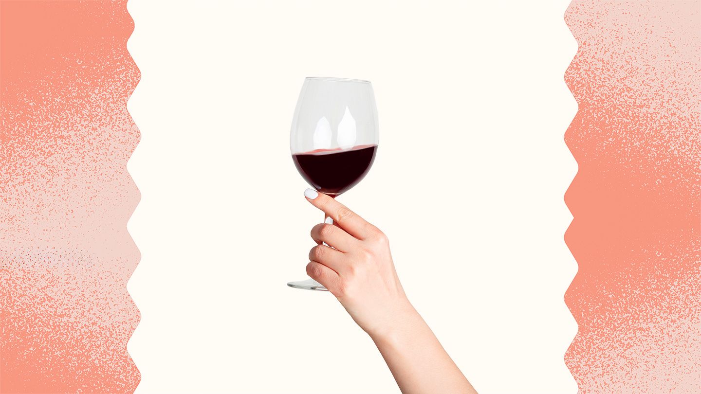 woman's hand holding glassof red wine