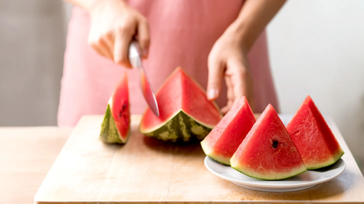 woman cutting fresh watermelon