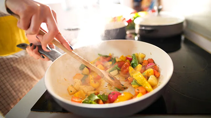 cooking peppers and vegetables in pan on stovetop