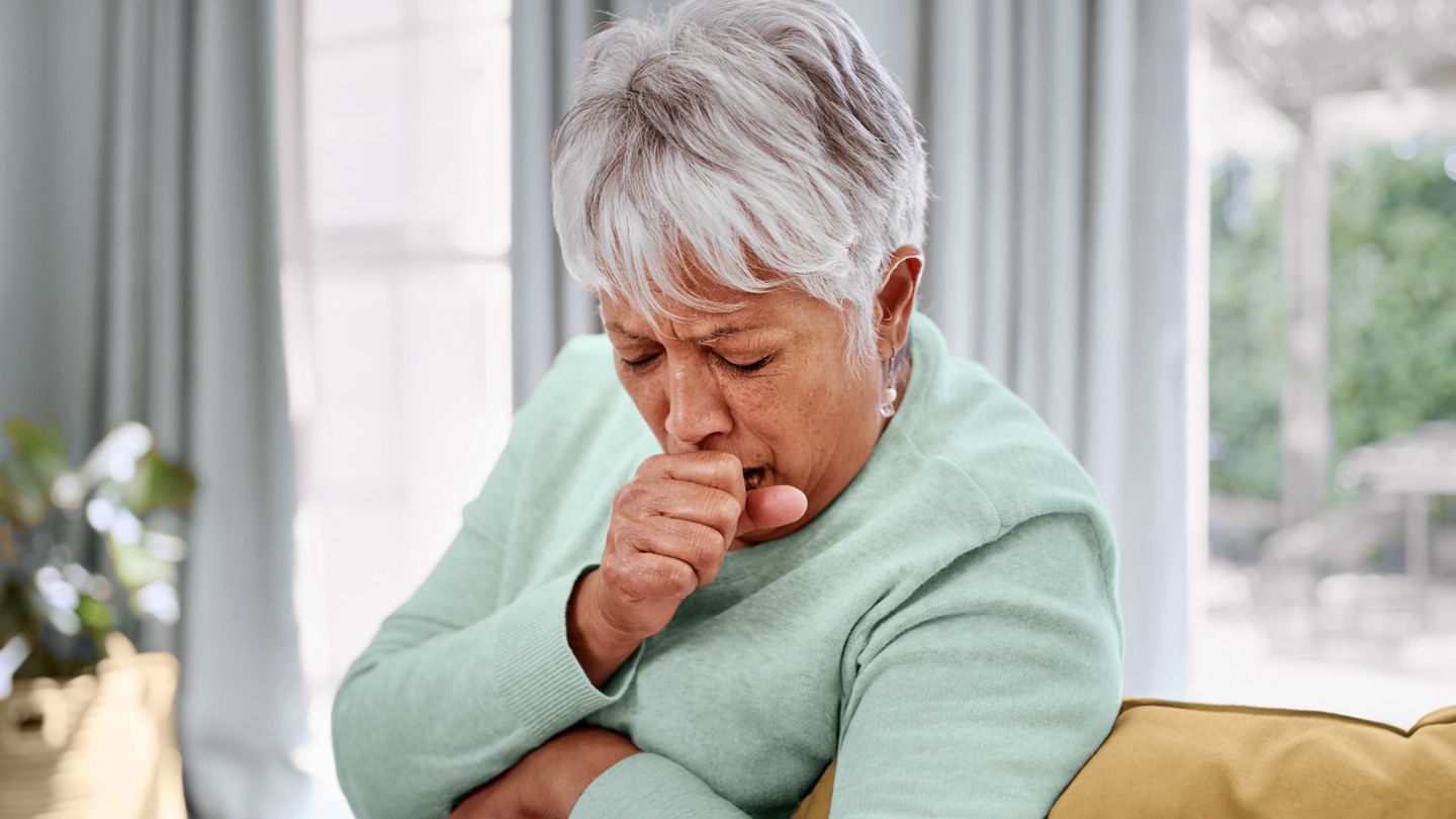 senior woman coughing at home