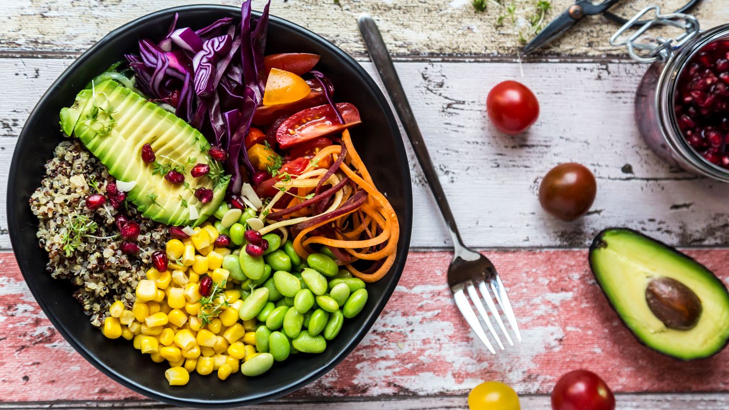 Quinoa veggie bowl of avocado, Edamame, tomatoes, corn, carrots, red cabbage and pomegranate seed