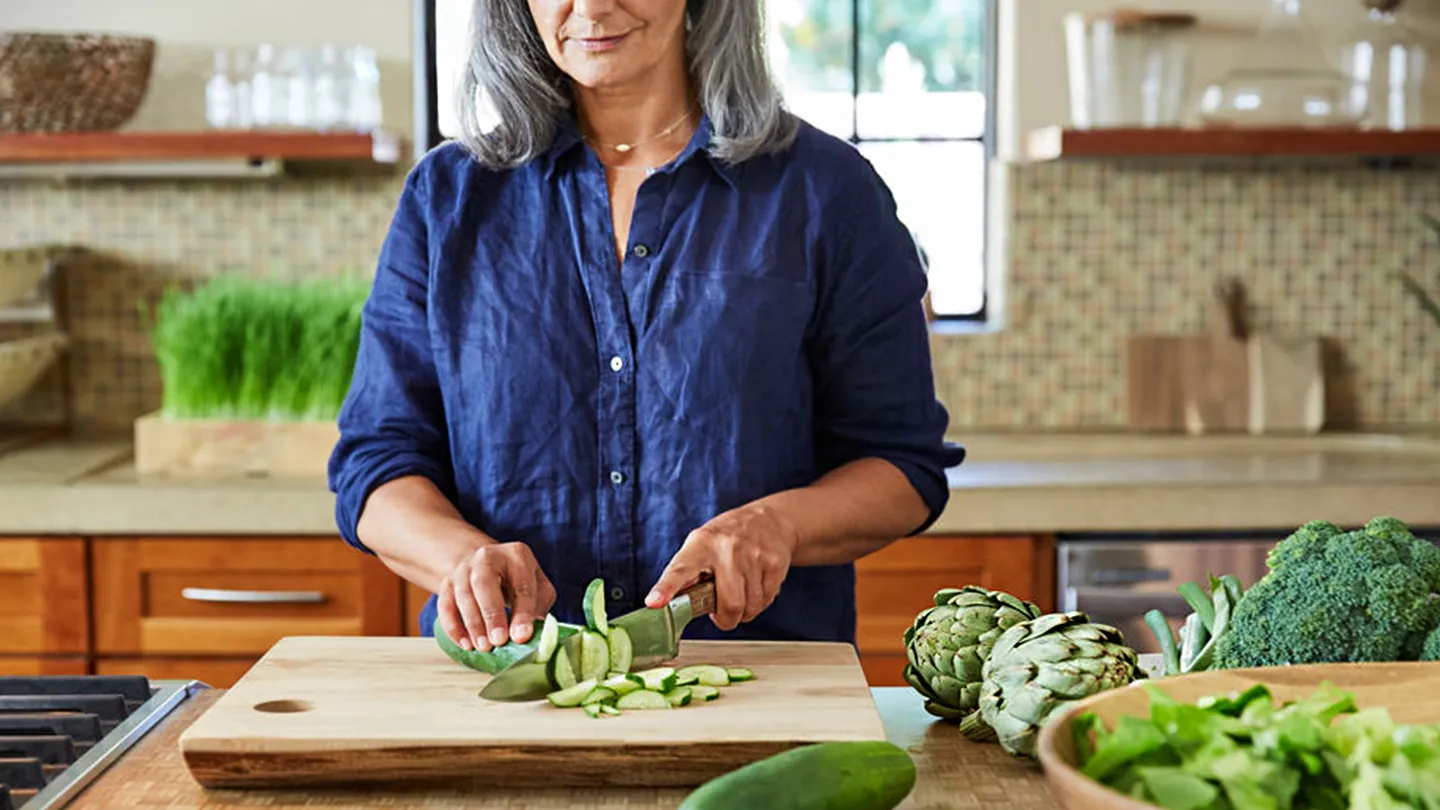 woman cutting vegetables in kitchen