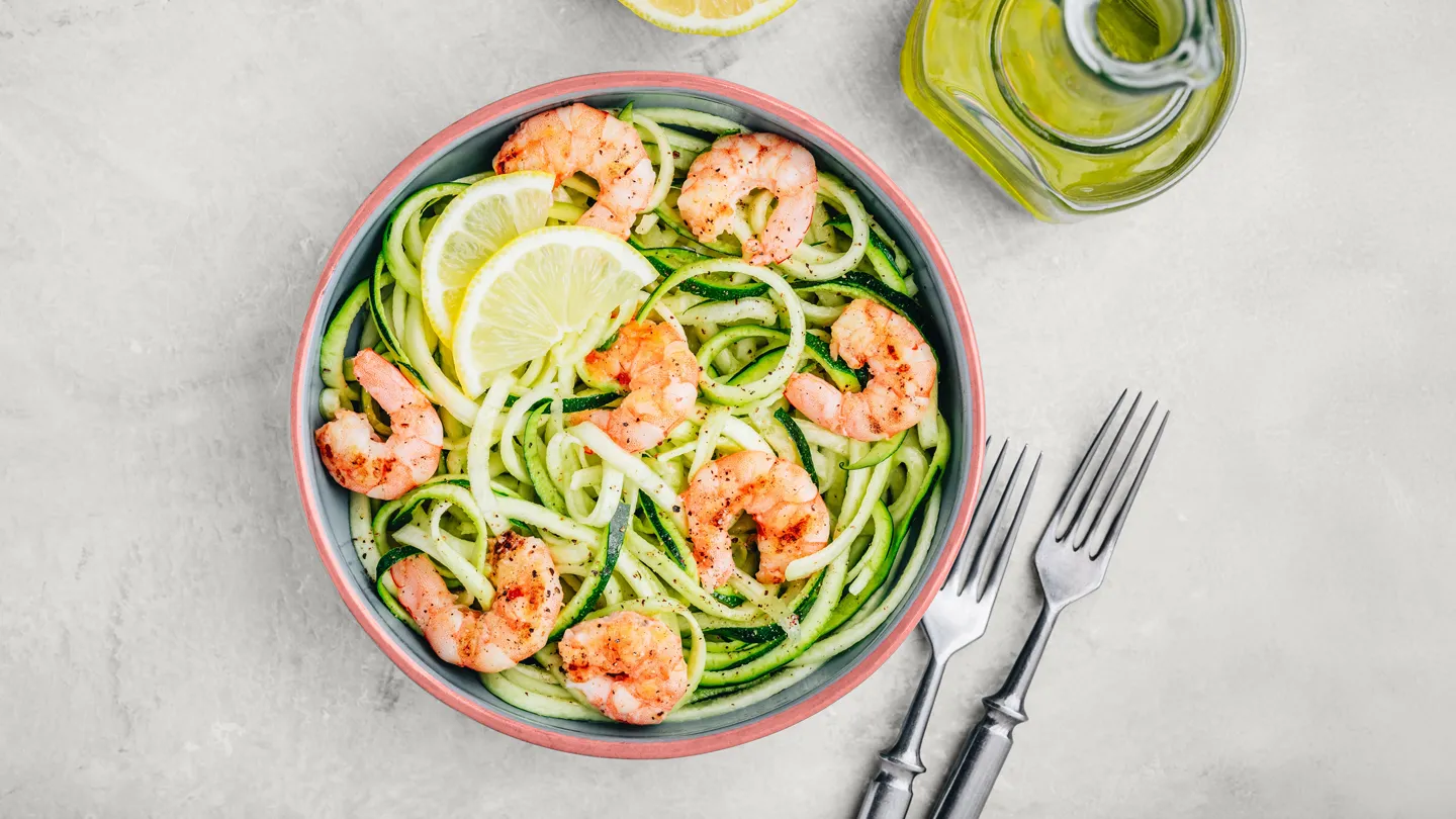 low carb meal of grilled shrimp on top of zucchini noodles or zoodles dinner bowl