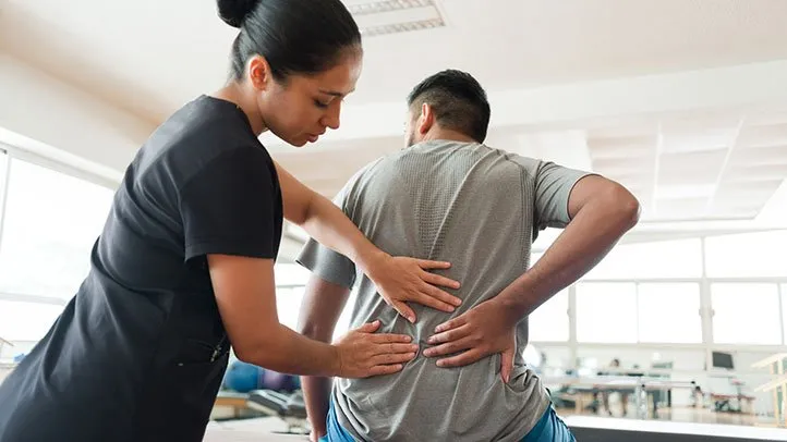 a man working with a physical therapist