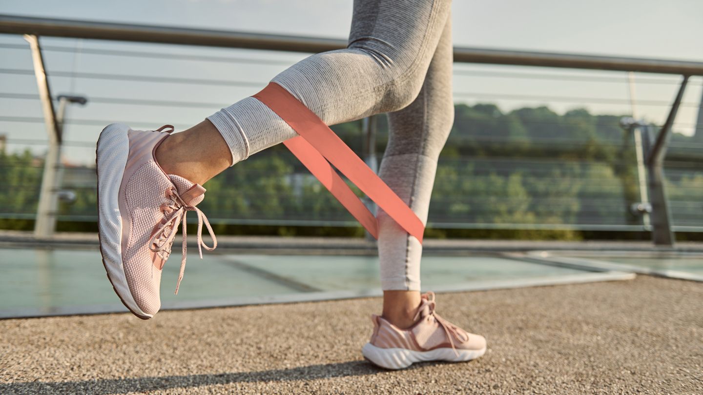 woman using resistance band while exercising outdoors