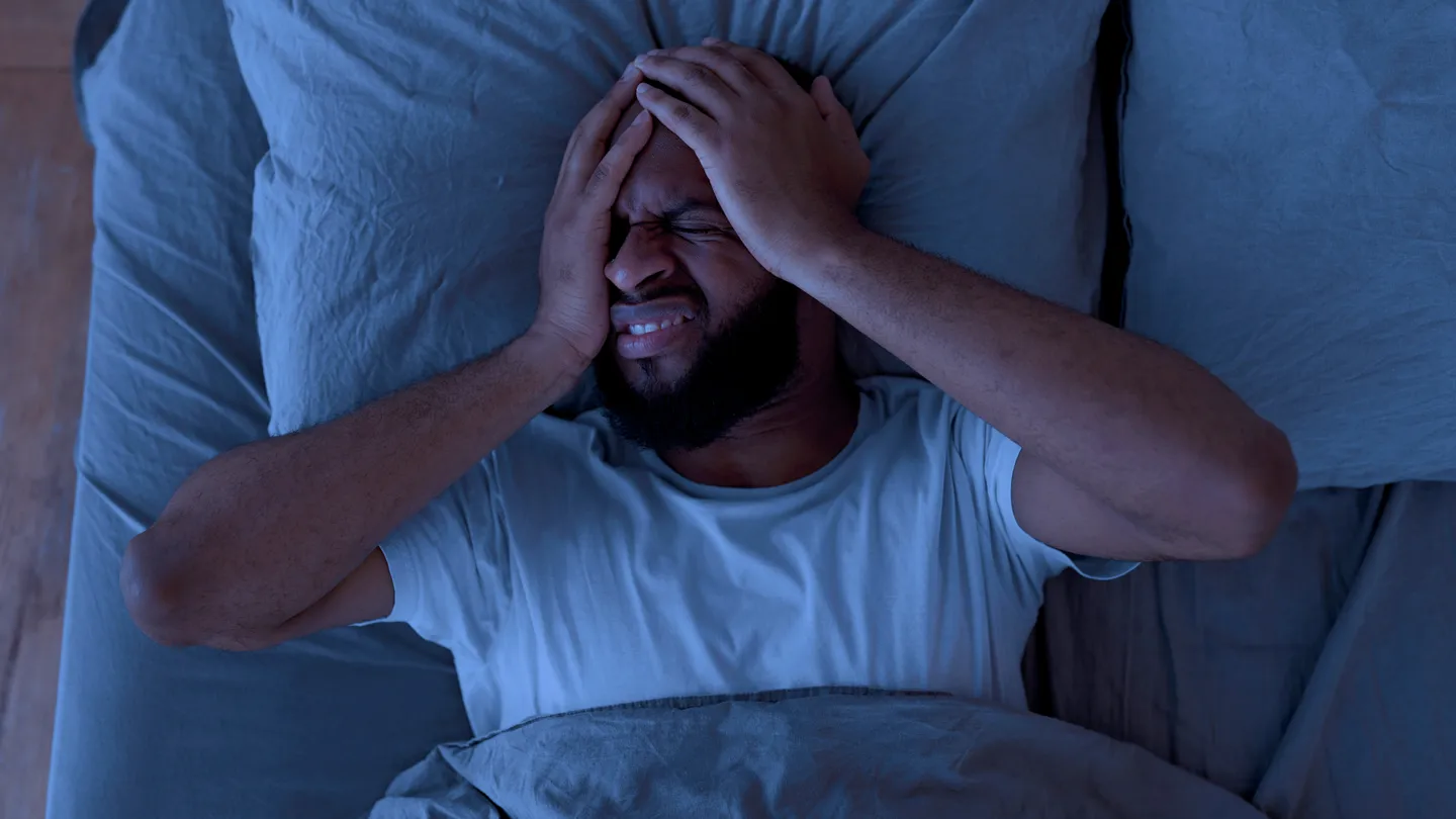 man in bed severe headache at night