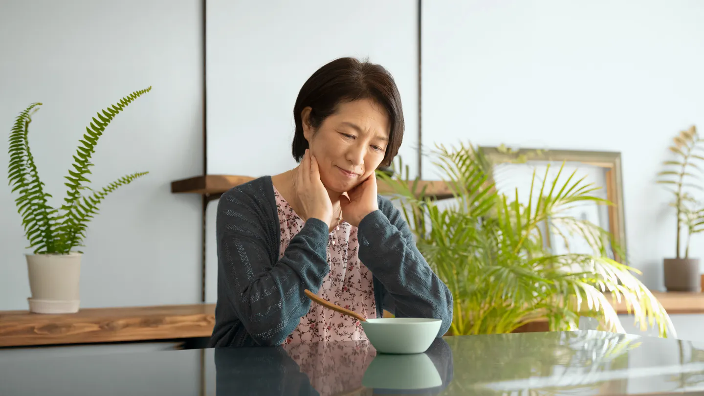 matture woman sitting n front of her meal not hungry