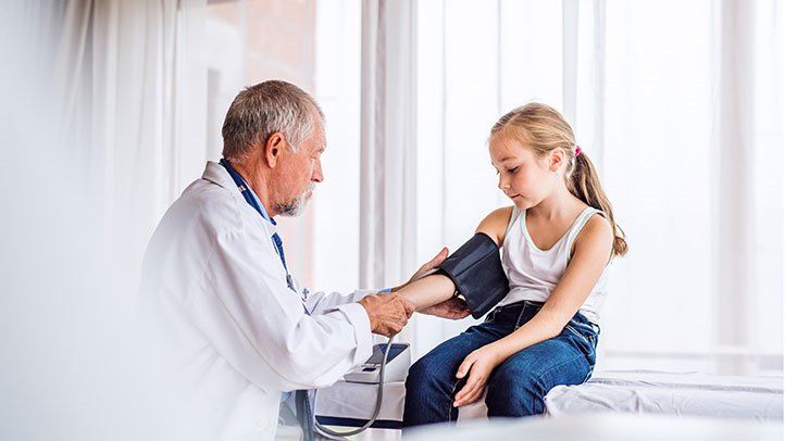 a doctor checking a child for high blood pressure
