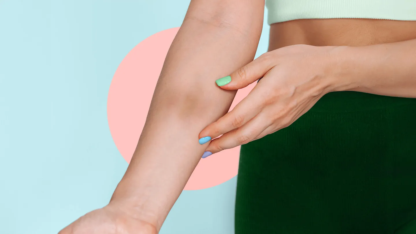 woman in workout gear hand touching other forearm with a large bruise coral circle behind