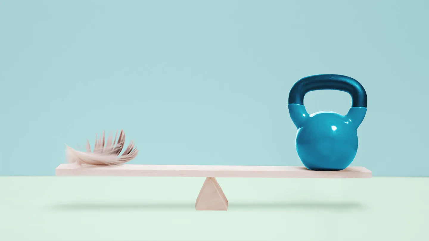 even weight feather and kettle bell on scale