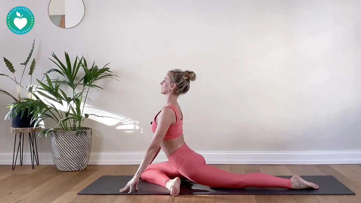 woman practicing yoga dressed in pink next to plants