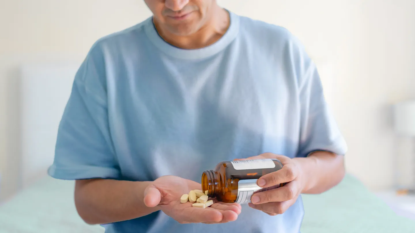 Man taking supplements in his bedroom