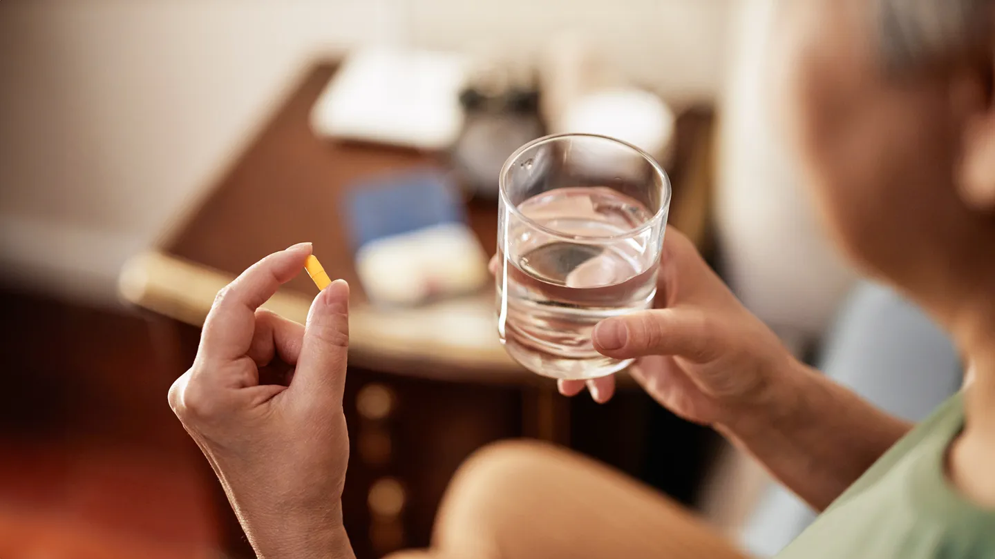 mature woman taking vitamin