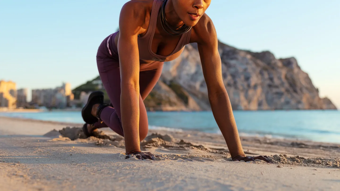 woman doing mountain climber exercise on beach
