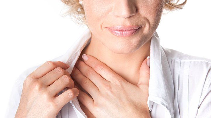 woman with gerd rubbing her sore throat