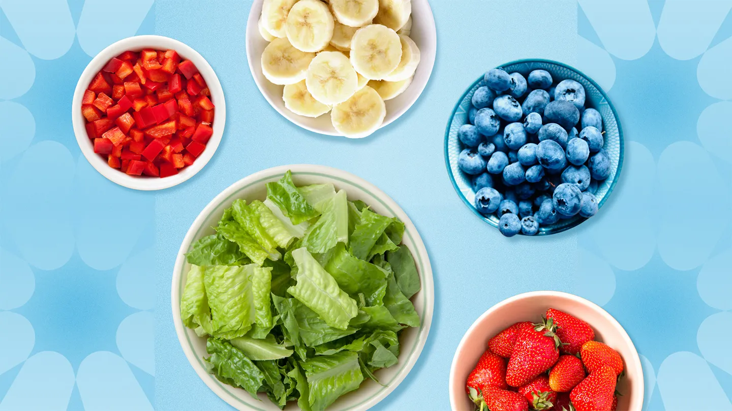 5 bowls of various fruits and vegetables on blue design background bell peppers bananas lettuce leafy greens strawberries blueberries