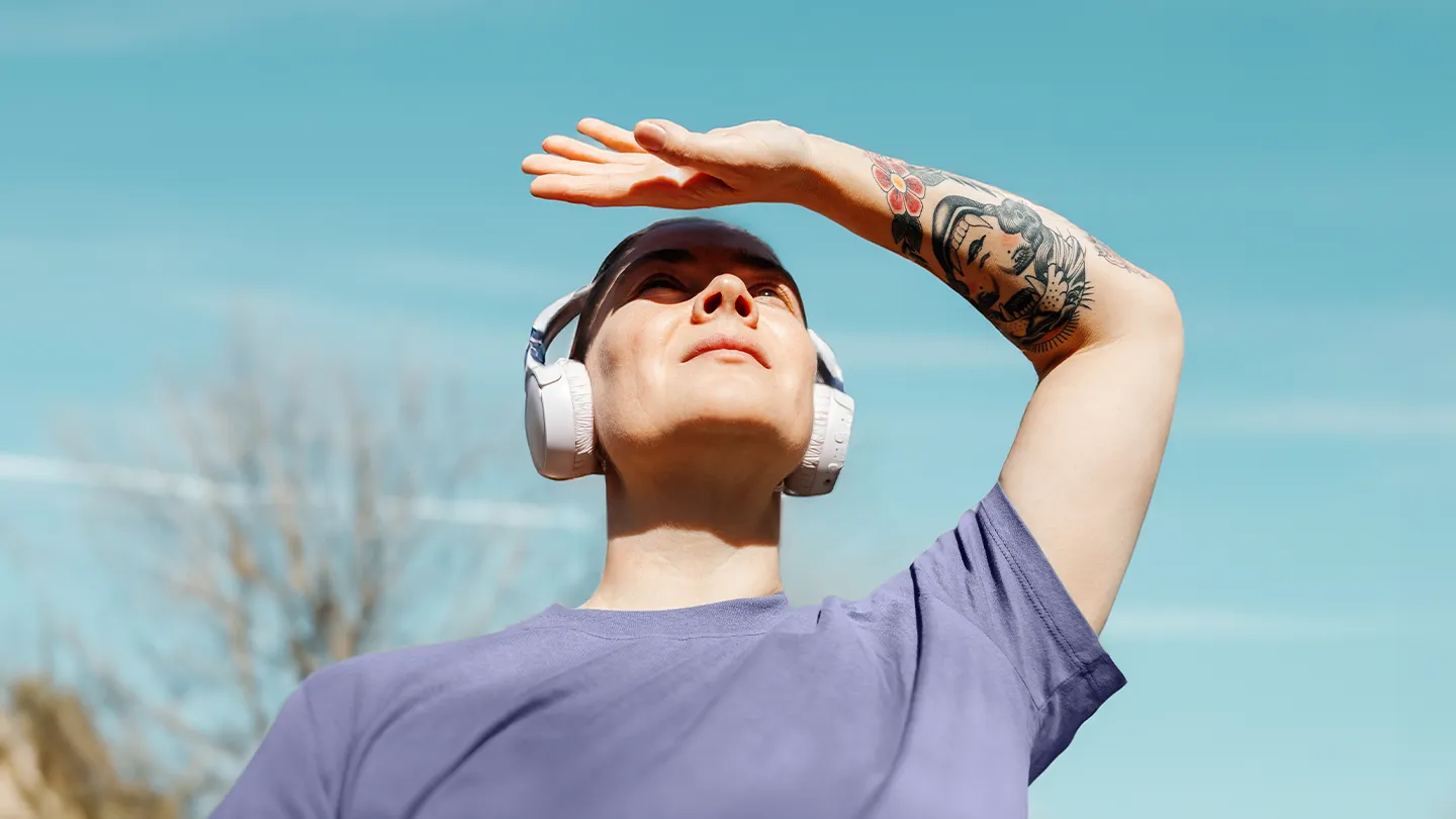 woman blocking the sun from hitting her face while walking outside