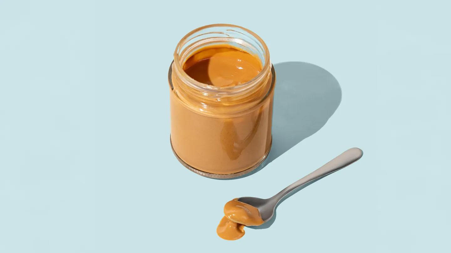 jar of peanut butter with a spoon next to it