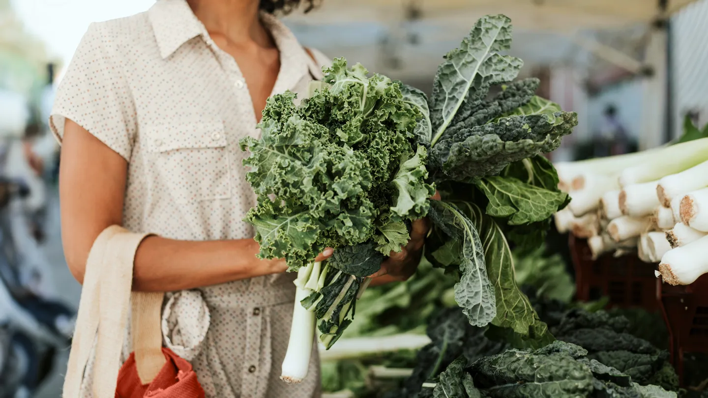 woman buying kale at farmer's market