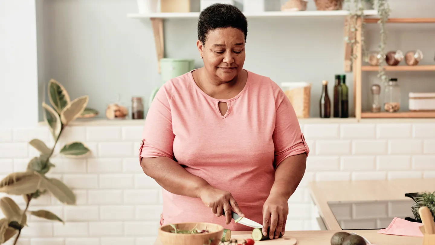 mature woman cutting vegetables