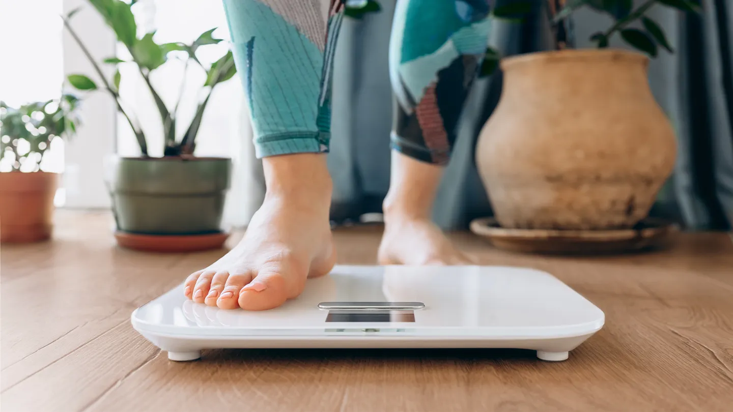 woman stepping onto a scale