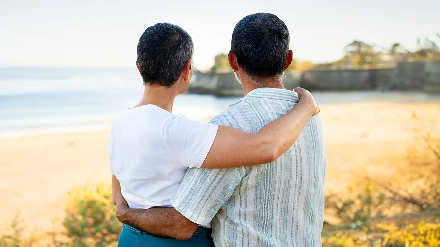 couple talking and comforting one another looking at coastline