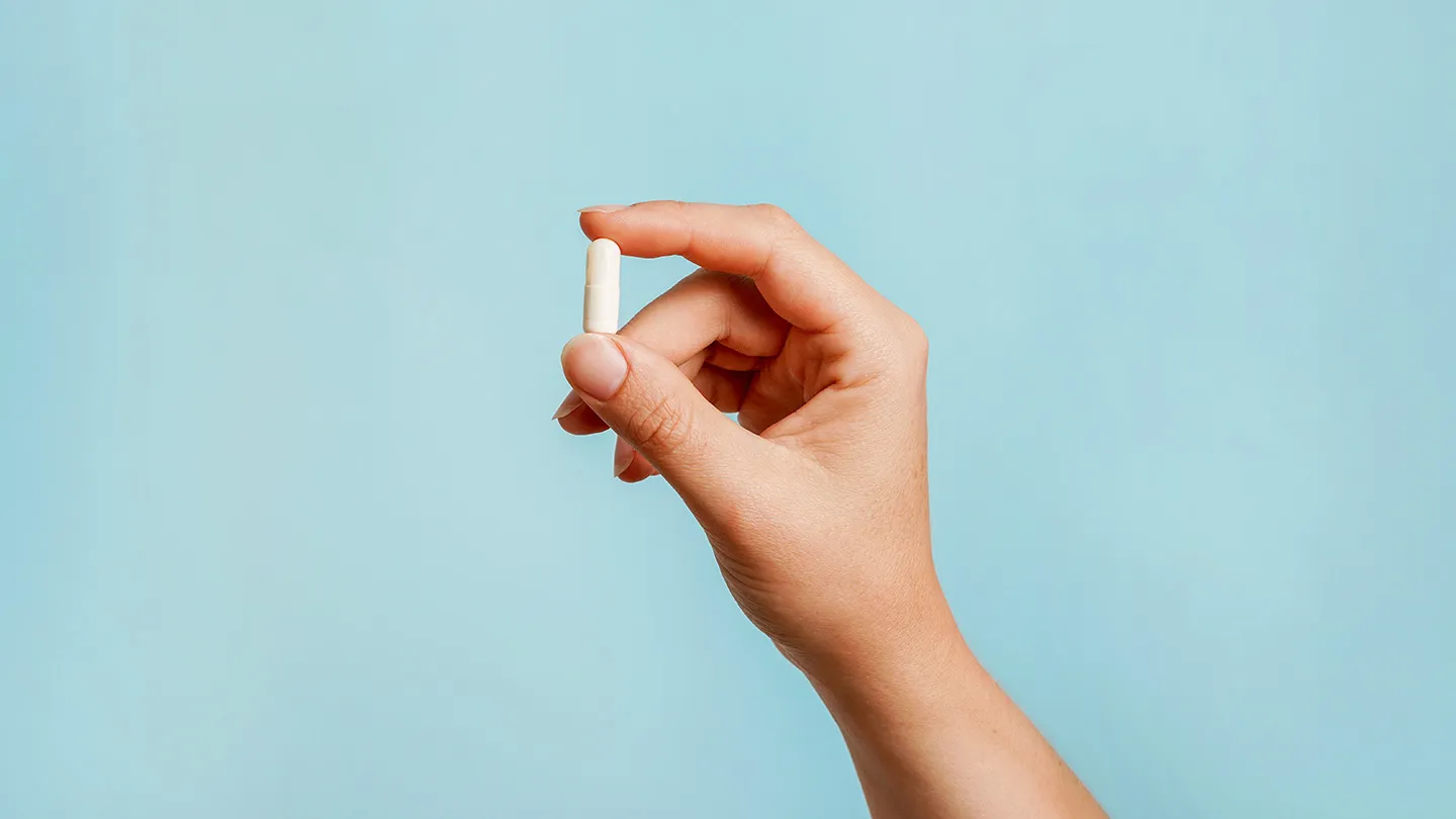 hand holding a magnesium supplement pill