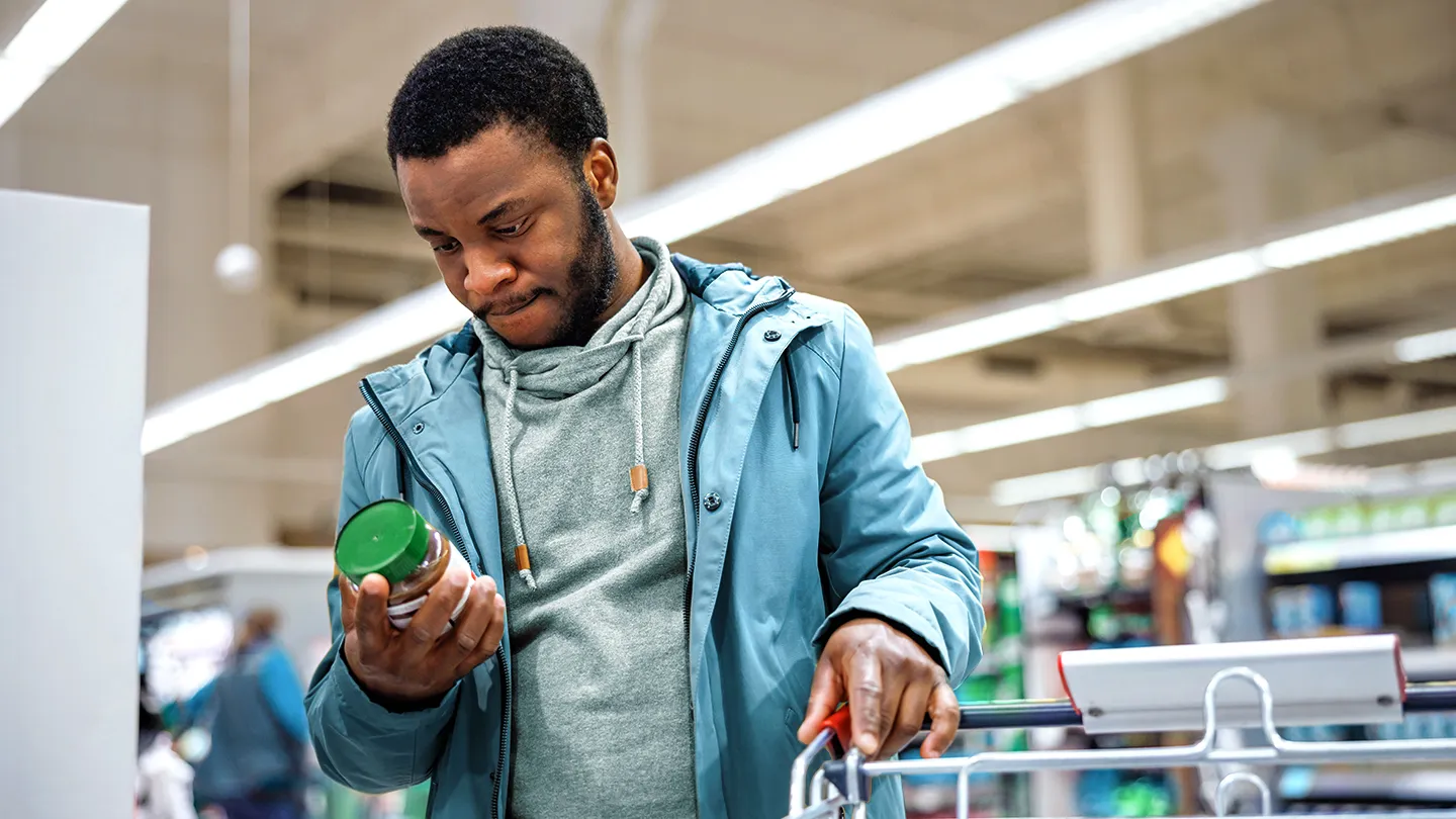 black man reading a nutrition facts label in the grocery store