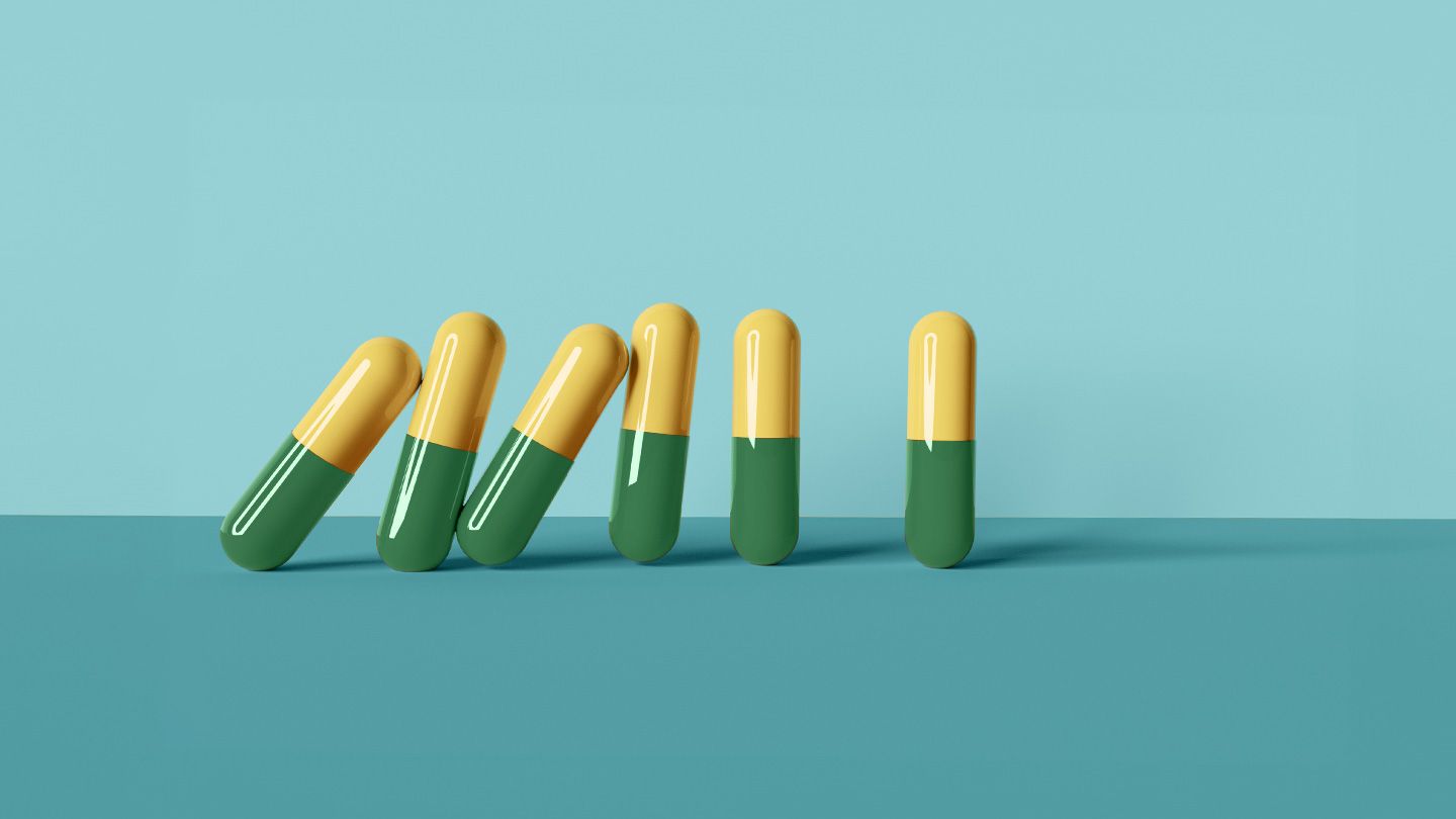 antidepressant capsule pills yellow and green domino effect falling into one another with singular final capsule pill