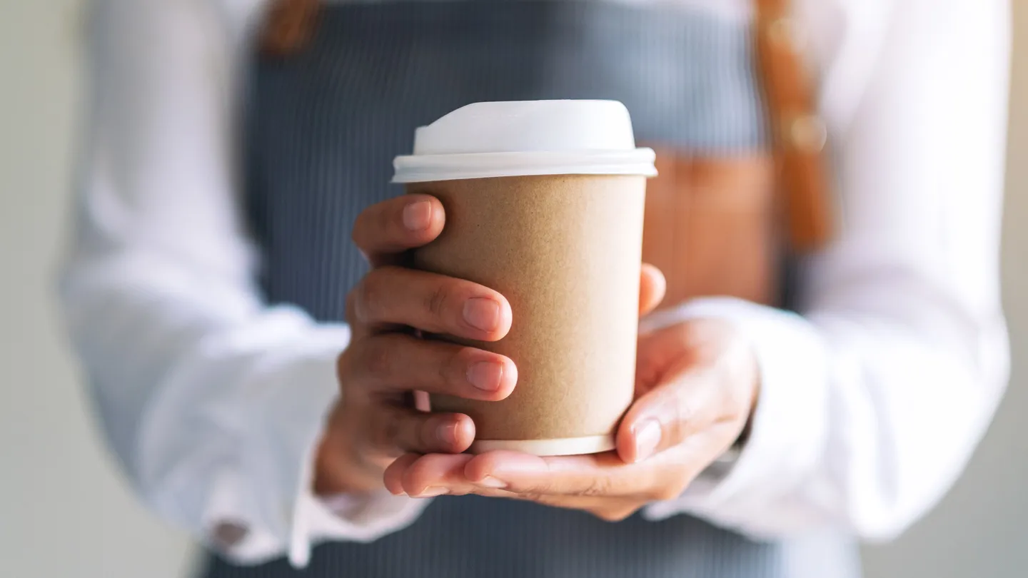 barista handing someone a cup of coffee