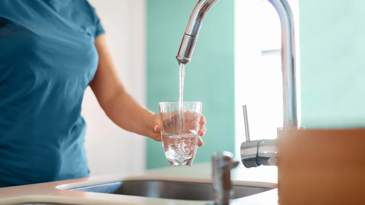 woman filling glass with tap water