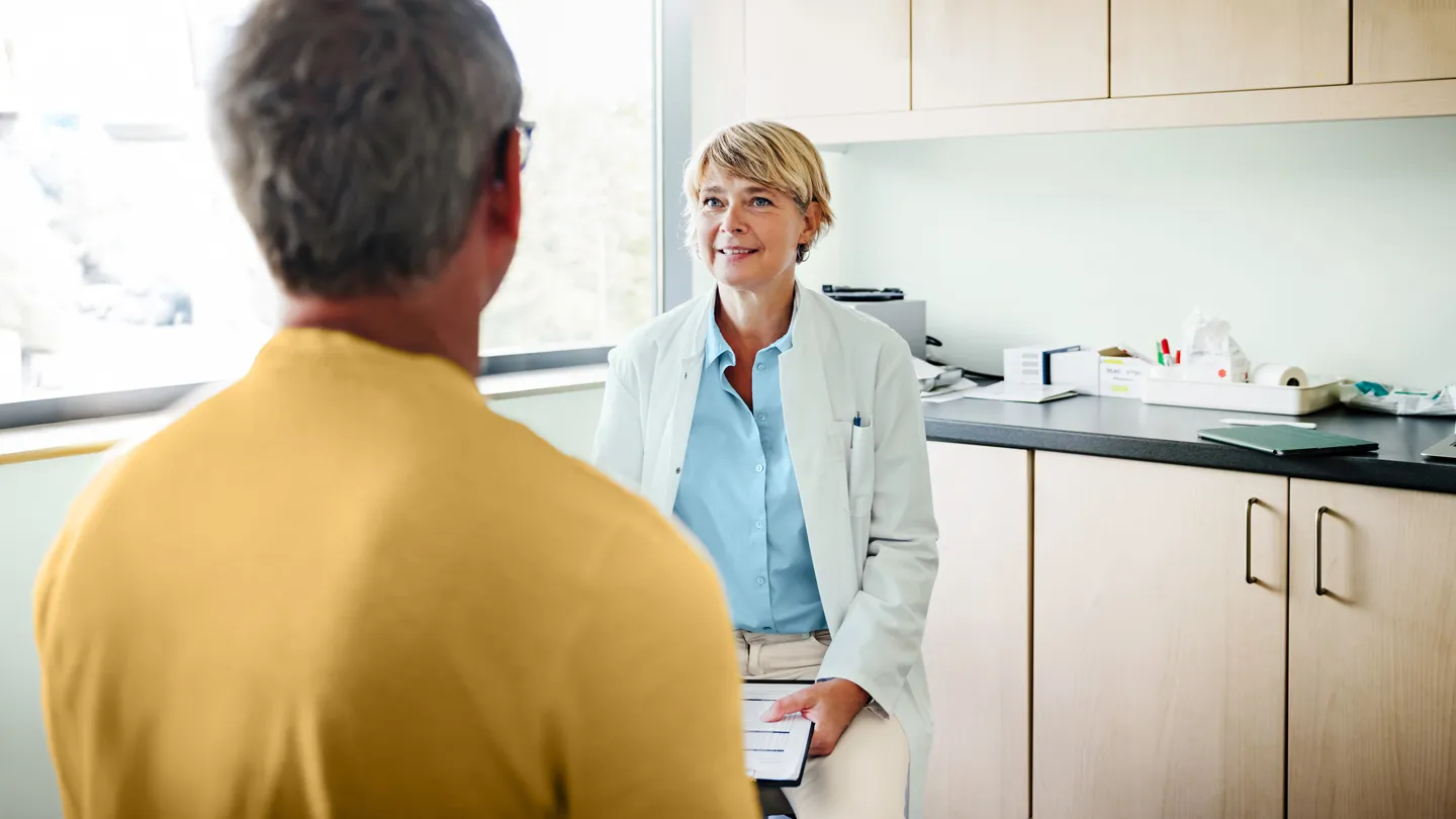 man talking with his doctor in exam room
