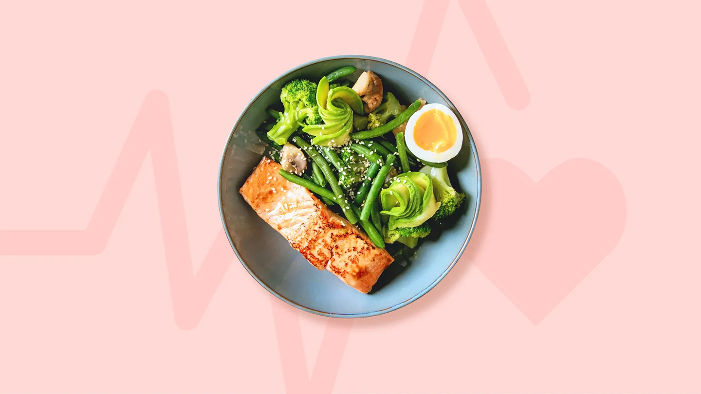 bowl plate of healthy protein sources like fatty fish salmon and eggs with cardiograph line leading to heart shape behind