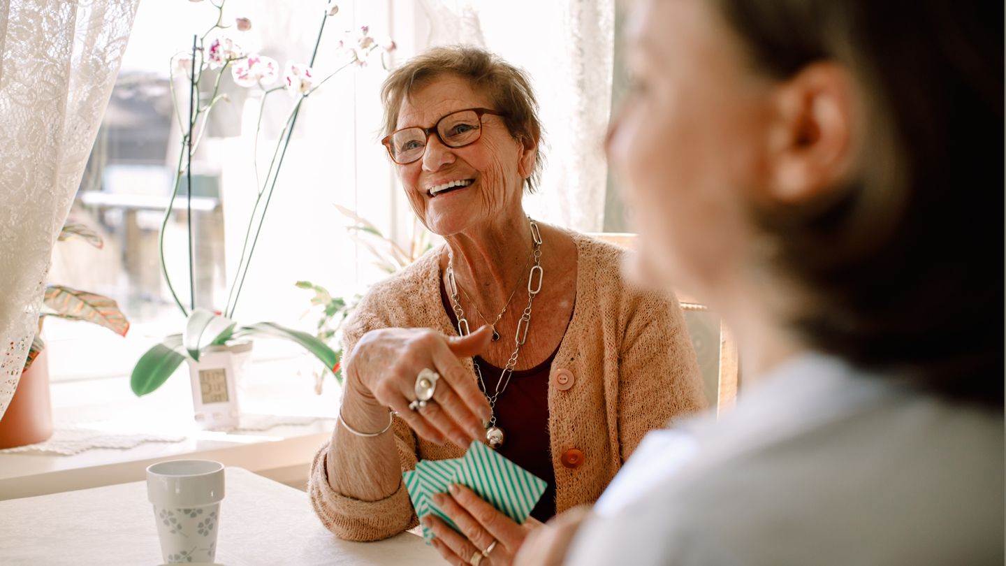 senior woman playing cards joyful