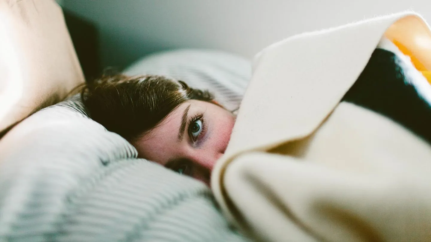 a woman laying awake in bed