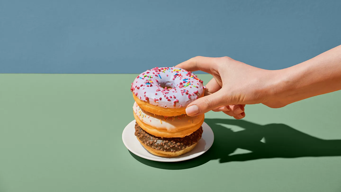 hand reaching for stack of donuts