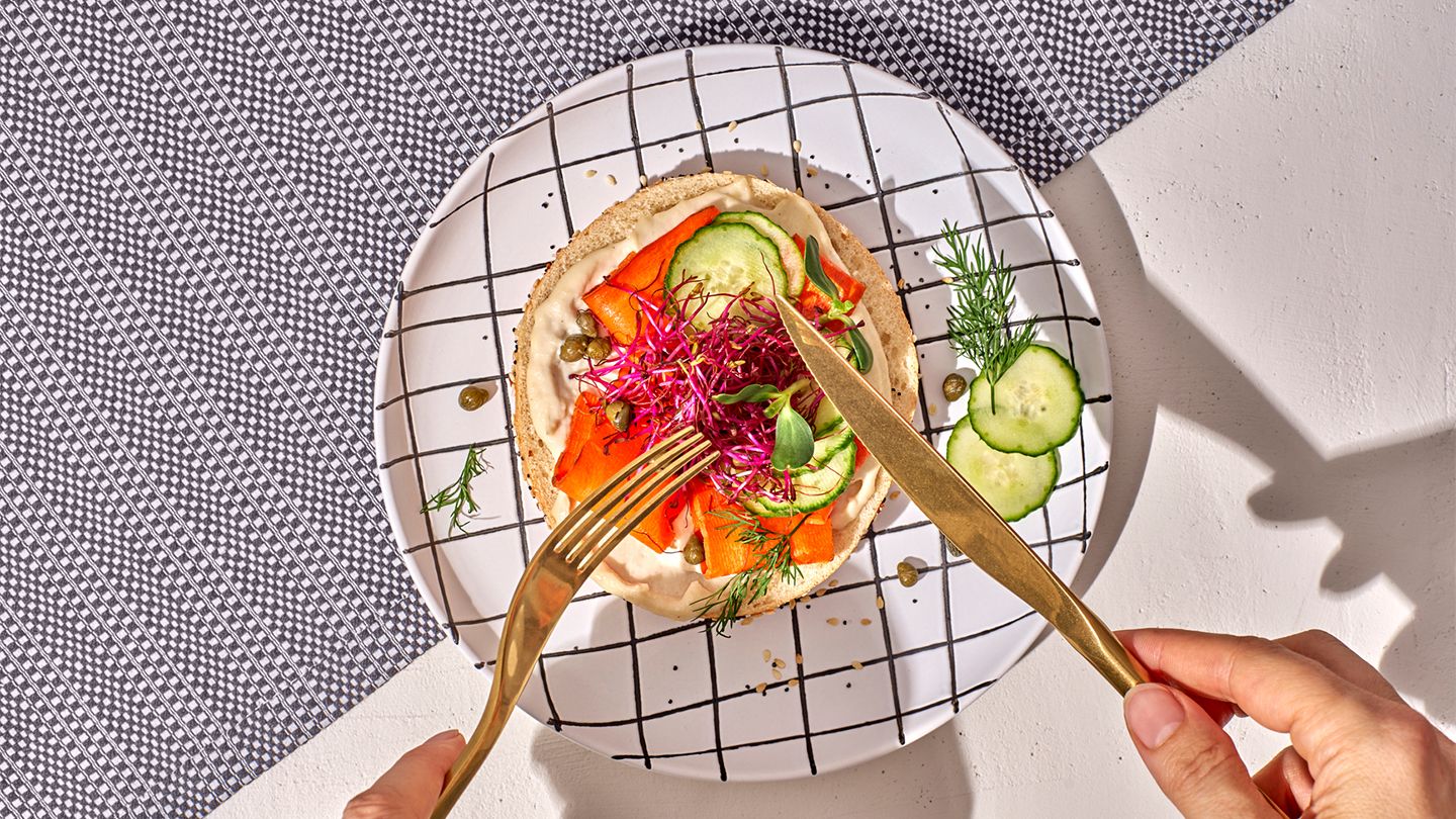 vegetables on bread with hummus fork and knife eating