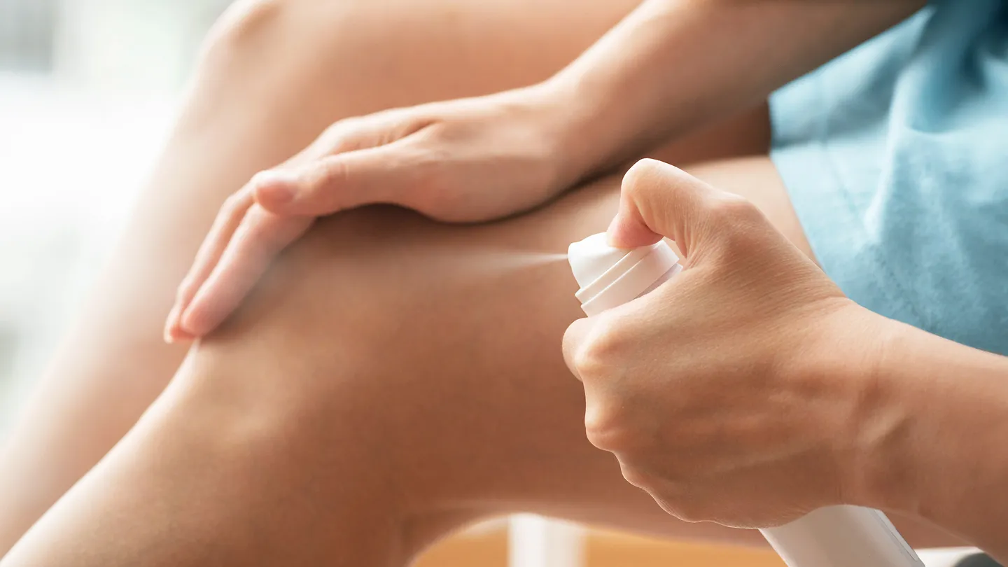 woman spraying magnesium oil on body